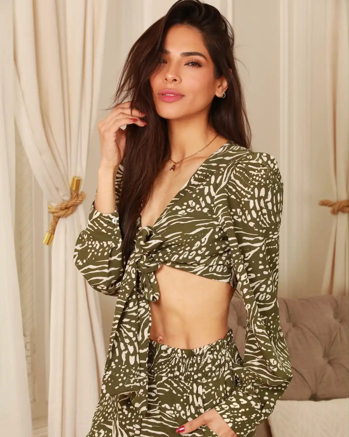 A woman in a green and white patterned two-piece crop top and shorts set.